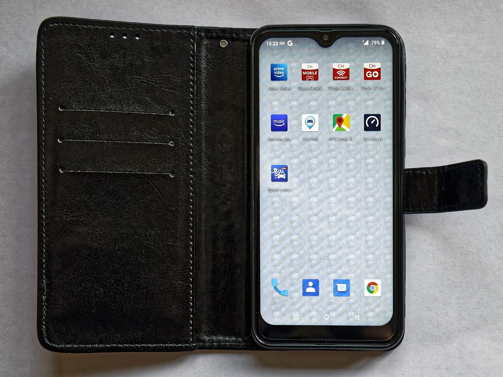 An open black folio-style phone case: three card slots on the inner left panel, the phone held in a shell on the right, and a clasp strap on the right edge.